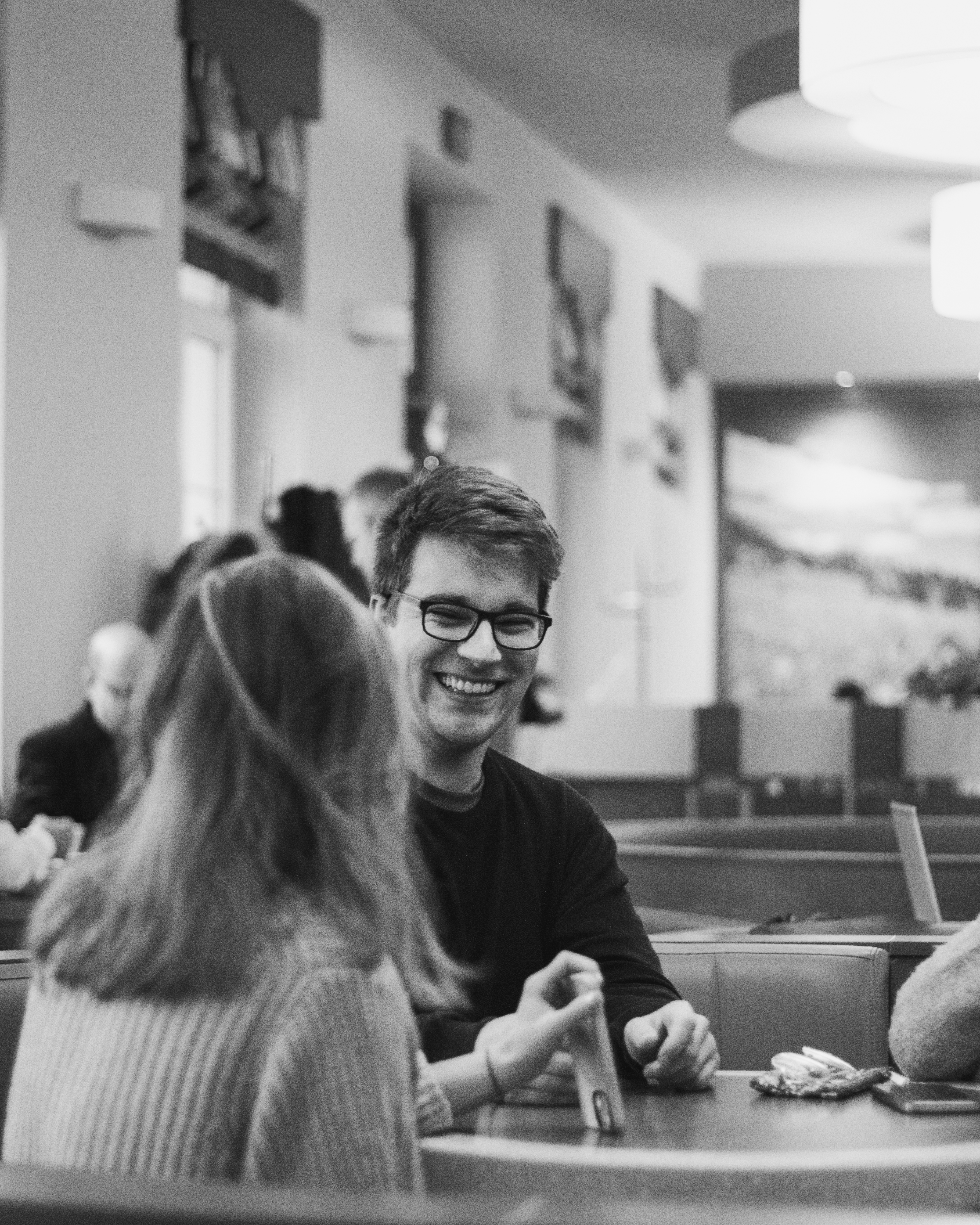 Dva muži diskutují nad notebookem, černo-bílá fotografie