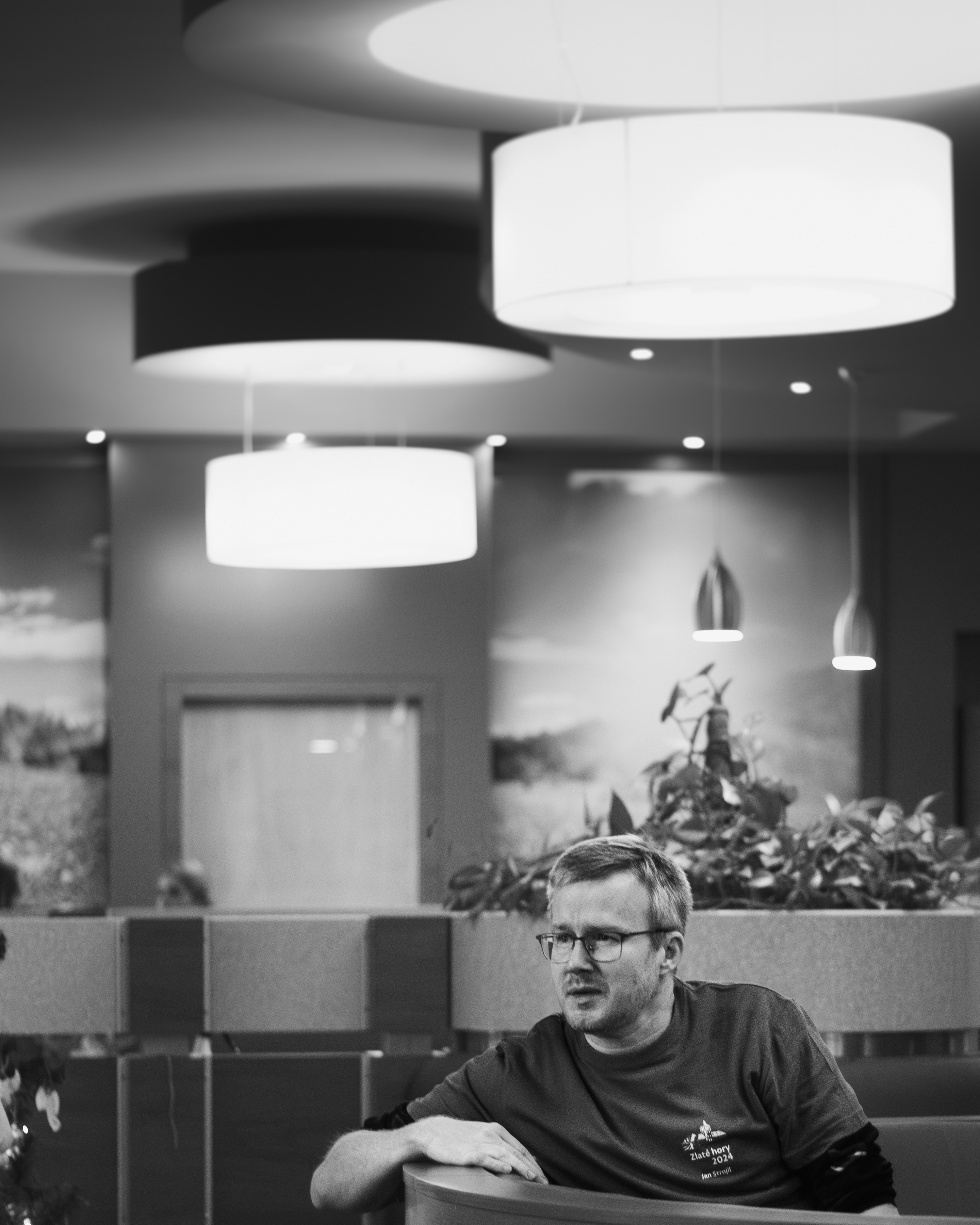 Muž v brýlích v kavárně sanatoria, černo-bílá fotografie