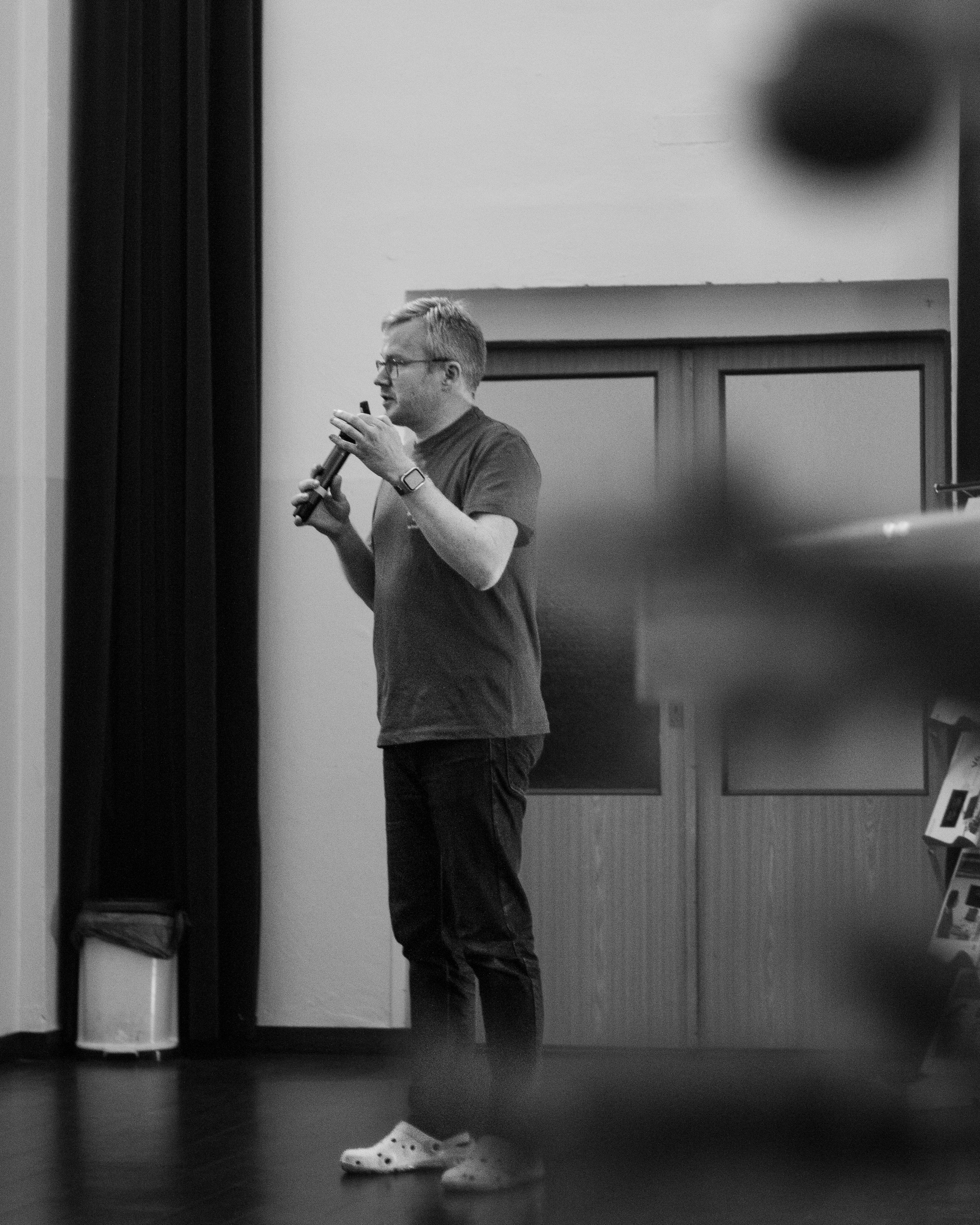 Přednášející mluví, celá postava, černo-bílá fotografie